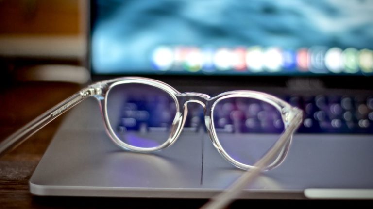 produktiver werden beschrieben durch eine Brille liegend auf einem Laptop