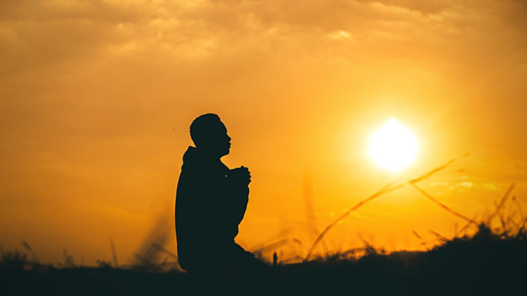 Negative Glaubenssätze auflösen und erkennen beschrieben durch die Silhouette eines Menschen im Sonnenuntergang
