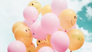 Toxische Positivität: Titelbild mit Luftballons, auf denen Smiley zu sehen sind